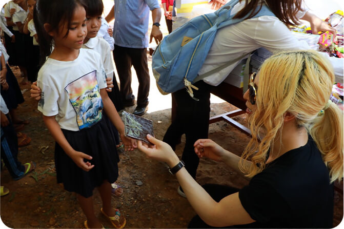 カンボジアの小学校で、ローランドが小学生と交流しているところを写した写真です